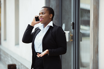 Image showing African-american businesswoman in office attire smiling, looks confident and happy, successful