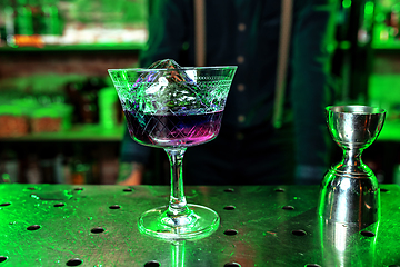 Image showing Close up of alcoholic cocktail, beverage, drink, prepared by professional barman in multicolored neon light