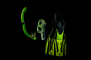 Image showing Professional sport equipment isolated on black studio background. Swimming flippers and mask.