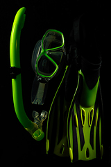 Image showing Professional sport equipment isolated on black studio background. Swimming flippers and mask.