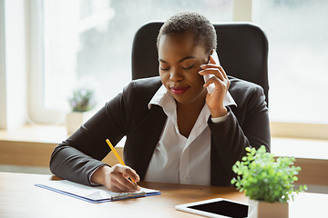 Image showing African-american businesswoman in office attire smiling, looks confident and happy, successful