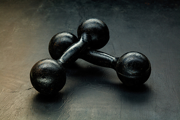 Image showing Professional sport equipment isolated on black studio background. Black gym weights.