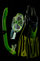 Image showing Professional sport equipment isolated on black studio background. Swimming flippers and mask.