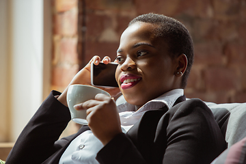 Image showing African-american businesswoman in office attire smiling, looks confident and happy, successful