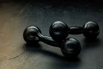 Image showing Professional sport equipment isolated on black studio background. Black gym weights.