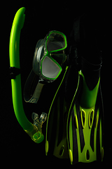 Image showing Professional sport equipment isolated on black studio background. Swimming flippers and mask.