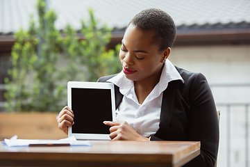 Image showing African-american businesswoman in office attire smiling, looks confident and happy, successful