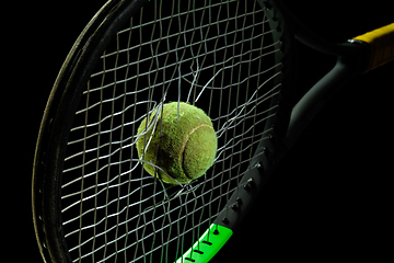 Image showing Professional sport equipment isolated on black studio background. Tennis racket and ball.