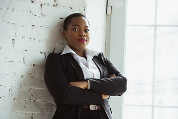 Image showing African-american businesswoman in office attire smiling, looks confident and happy, successful