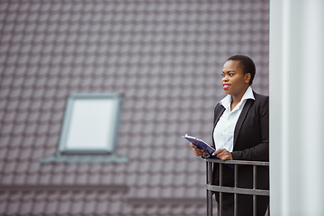 Image showing African-american businesswoman in office attire smiling, looks confident and happy, successful