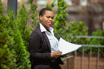 Image showing African-american businesswoman in office attire smiling, looks confident and happy, successful