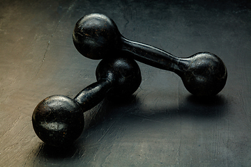 Image showing Professional sport equipment isolated on black studio background. Black gym weights.