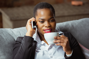 Image showing African-american businesswoman in office attire smiling, looks confident and happy, successful