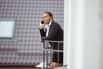 Image showing African-american businesswoman in office attire smiling, looks confident and happy, successful