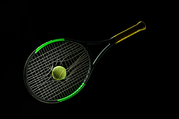 Image showing Professional sport equipment isolated on black studio background. Tennis racket and ball.