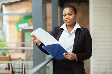 Image showing African-american businesswoman in office attire smiling, looks confident and happy, successful