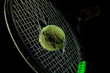 Image showing Professional sport equipment isolated on black studio background. Tennis racket and ball.