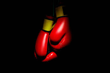 Image showing Professional sport equipment isolated on black studio background. Boxers red gloves.