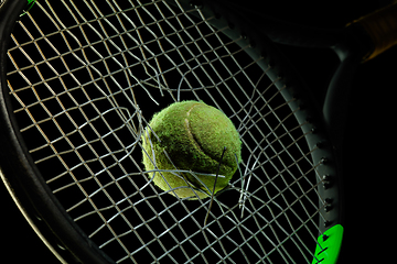 Image showing Professional sport equipment isolated on black studio background. Tennis racket and ball.