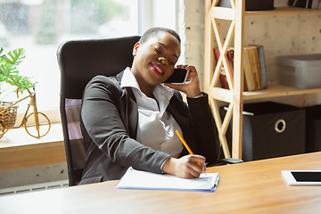 Image showing African-american businesswoman in office attire smiling, looks confident and happy, successful