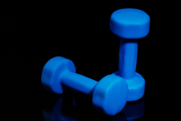 Image showing Professional sport equipment isolated on black studio background. Blue gym weights.