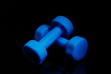 Image showing Professional sport equipment isolated on black studio background. Blue gym weights.