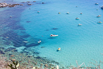 Image showing Boats near a rock stone coast. Scenic view of tipycal rocky coas