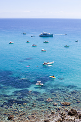 Image showing Boats near a rock stone coast. Scenic view of tipycal rocky coas