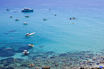 Image showing Boats near a rock stone coast. Scenic view of tipycal rocky coas