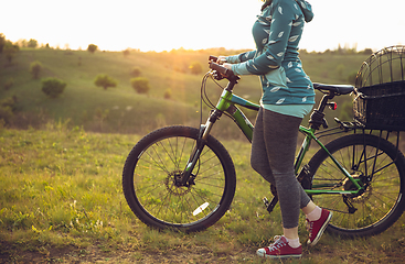 Image showing Young woman having fun near countryside park, riding bike, traveling at spring day