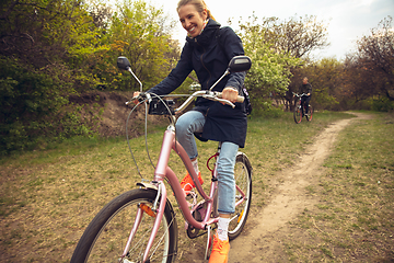 Image showing Best friends having fun near countryside park, riding bikes, spending time healthy