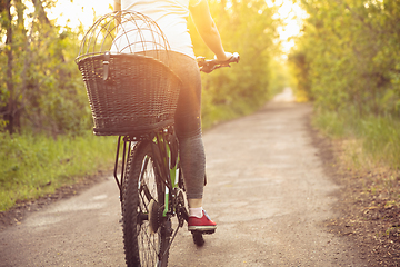 Image showing Young woman having fun near countryside park, riding bike, traveling at spring day