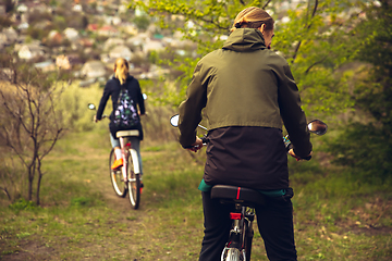 Image showing Best friends having fun near countryside park, riding bikes, spending time healthy