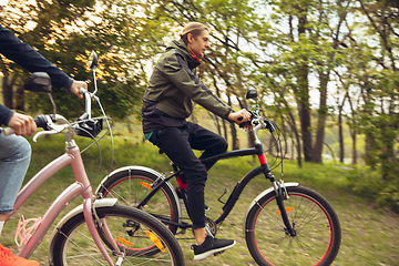 Image showing Best friends having fun near countryside park, riding bikes, spending time healthy