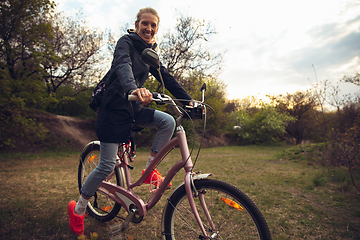 Image showing Young woman having fun near countryside park, riding bike, traveling at spring day