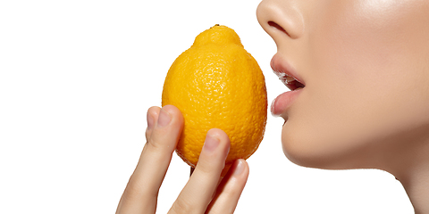 Image showing Freshness. Close up of beautiful young woman biting juicy lemon over white background. Cosmetics and makeup, natural and eco treatment, skin care. Flyer, proposal.