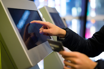 Image showing Woman using credit card to pay on the automatic cinema ticketing