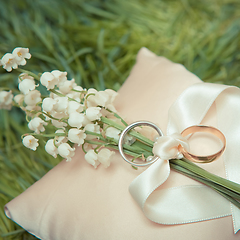 Image showing white gold wedding rings with a bouquet 