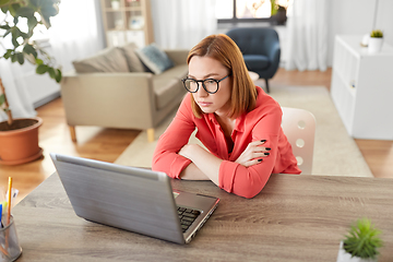 Image showing bored woman with laptop working at home office