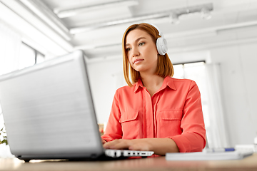 Image showing woman in headphones with laptop working at home