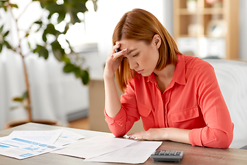 Image showing woman with calculator and papers working at home