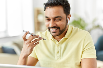 Image showing man recording voice on smartphone at home office