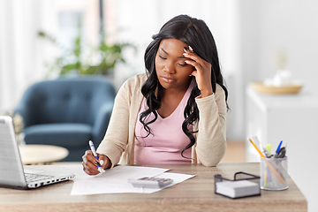 Image showing woman with calculator and papers working at home