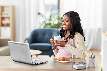 Image showing happy woman with laptop and coffee at home office