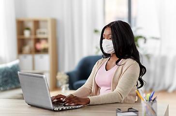 Image showing woman in mask with laptop working at home office