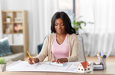 Image showing female architect with house model and blueprint