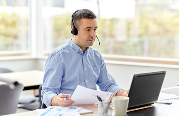 Image showing man with headset and laptop working at home