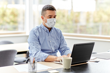 Image showing man in mask with laptop working at home office