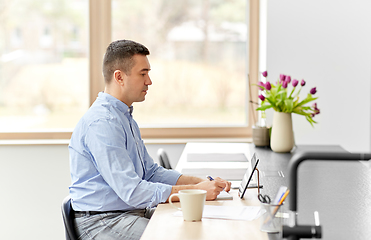 Image showing man with tablet computer working at home office