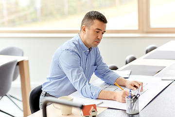 Image showing architect with blueprint working at home office